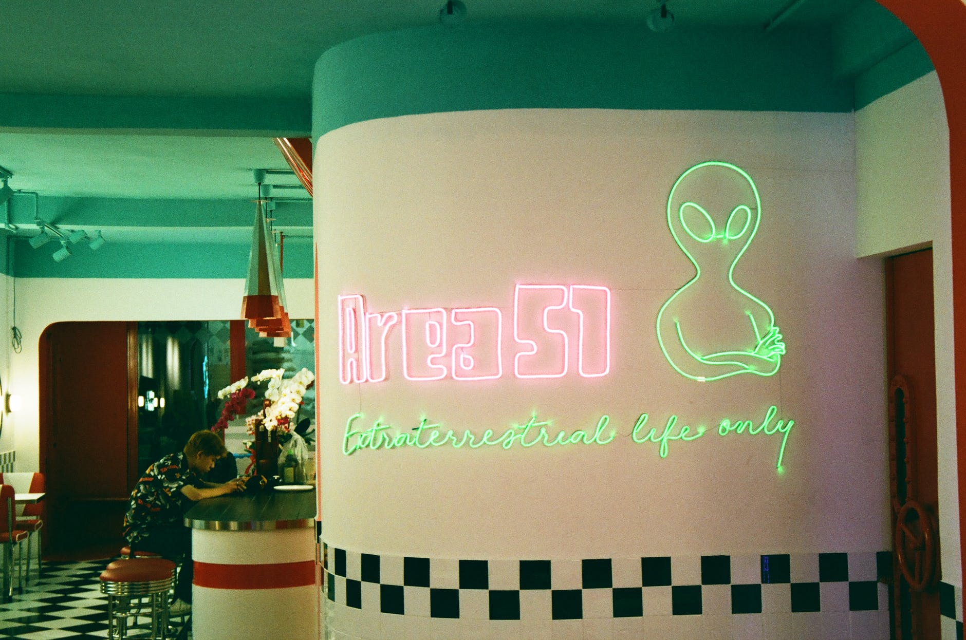 a pink and green neon signage on a wall